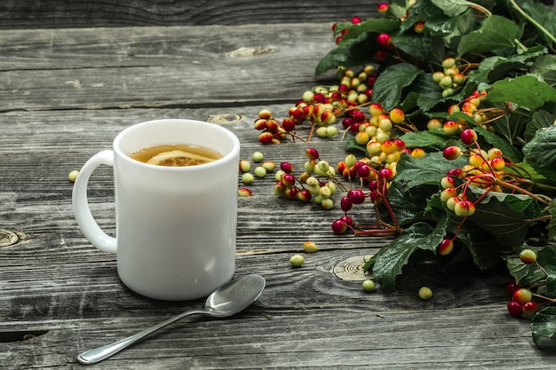 la tazza di tè su un bellissimo maglione invernale in legno, frutti di bosco, autunno