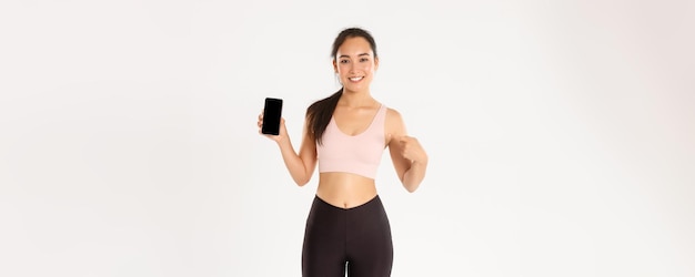 La tecnologia sportiva e il concetto di stile di vita attivo hanno soddisfatto gli sport attraenti della ragazza asiatica sorridente di forma fisica