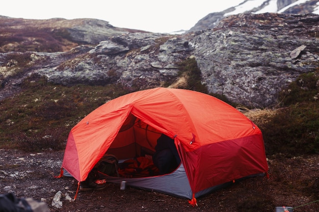 La tenda rossa si trova a terra da qualche parte nelle montagne