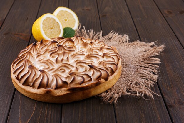 La torta saporita del limone con crema bianca è servito sulla tavola di legno