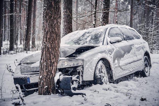 La vista frontale dell'auto è scivolata e si è schiantata contro un albero su una strada innevata.