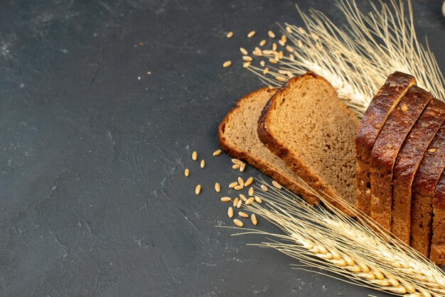 La vista frontale delle fette di pane nero picchia gli spicchi su sfondo nero con spazio libero