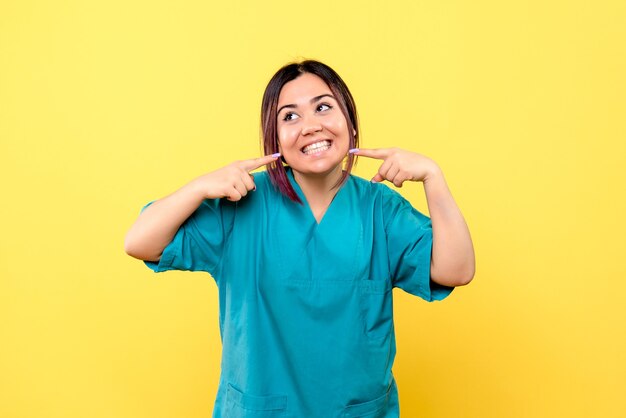 La vista laterale del medico sorridente del buon dottore sta parlando dell'importanza del buon umore