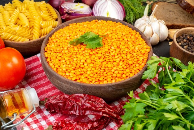 La vista laterale del pane delle verdure fresche affetta le lenticchie rosse in una pasta marrone del pepe della ciotola