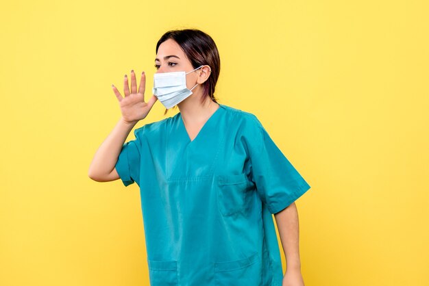 La vista laterale di un medico in maschera incoraggia le persone