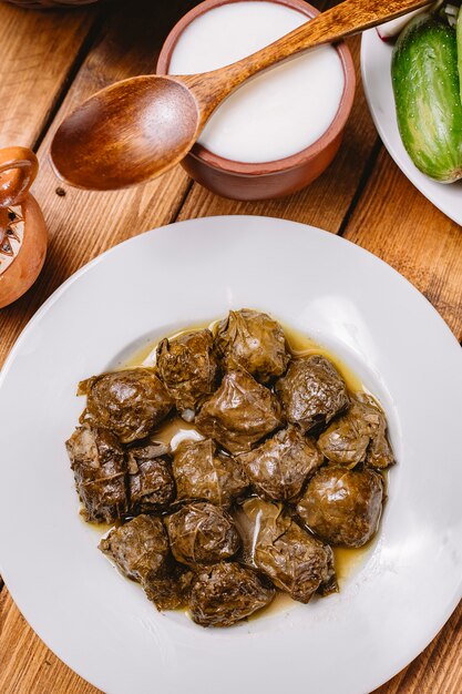 La vista superiore del dolma delle foglie di vite è servito con yogurt