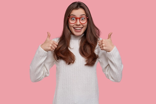 La vita in su di una donna attraente accetta il piano degli amici, dà un'opinione positiva, tiene il pollice in alto, guarda felice la telecamera