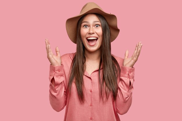 La vita in su di una donna europea felicissima gesticola attivamente, esclama con felicità