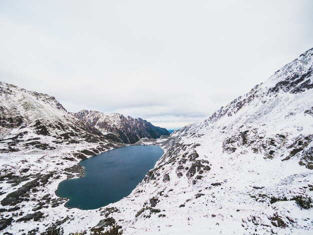 Lago circondato dai monti Tatra coperti di neve in Polonia