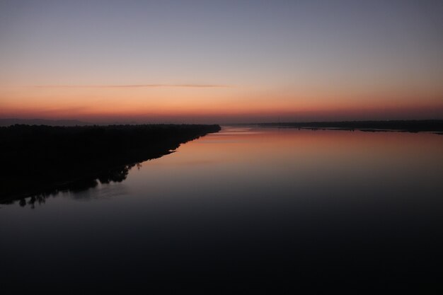 Lago con spiaggia al tramonto