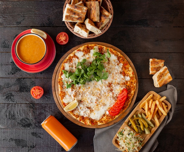 Lahmajun turco con formaggio, servito con limone, prezzemolo con zuppa di pomodoro