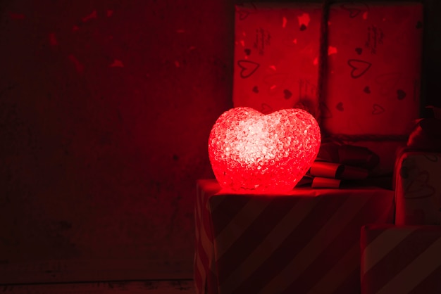 Lampada illuminata a forma di cuore vicino a scatole attuali