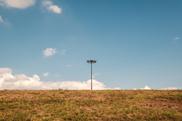 Lampione in mezzo a un campo contro un cielo blu