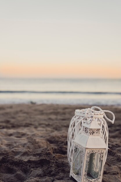 Lanterna in spiaggia al tramonto