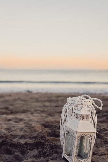 Lanterna in spiaggia al tramonto