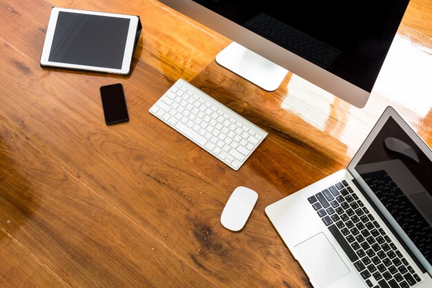 Laptop, computer e mobile su un tavolo di legno