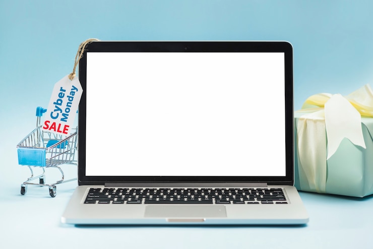 Foto gratuito laptop vicino carrello della spesa, tag e scatola regalo