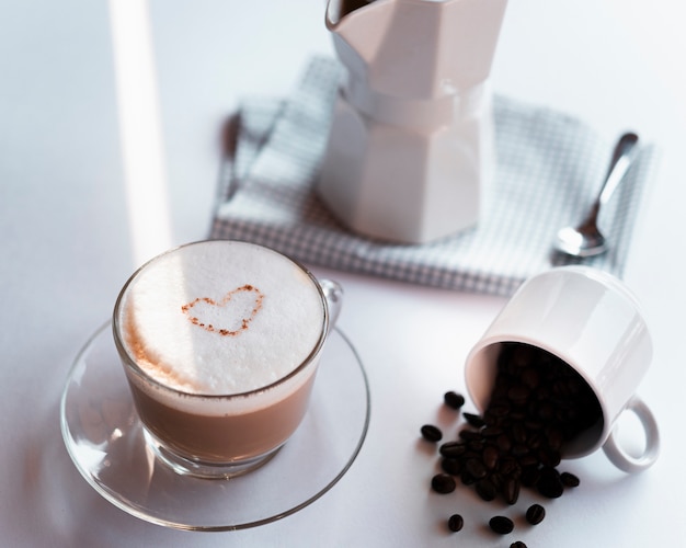 Latte della tazza di caffè del primo piano con il bollitore