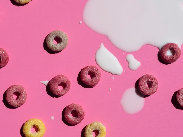 Latte e cereali sul primo piano rosa del fondo