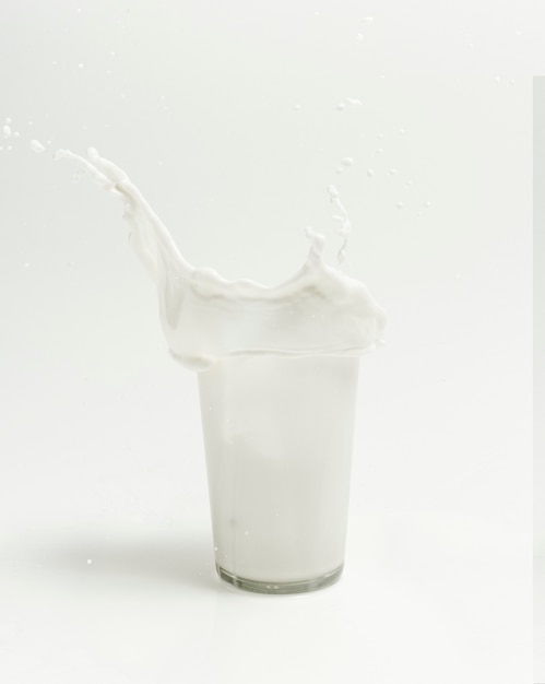 Latte fresco che spruzza da un bicchiere