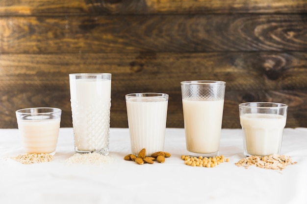 Latte in diversi tipi di bicchieri e cereali