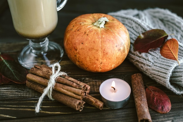 Latte piccante della zucca su una tavola di legno con un maglione