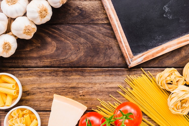 Lavagna e formaggio vicino pasta e verdure