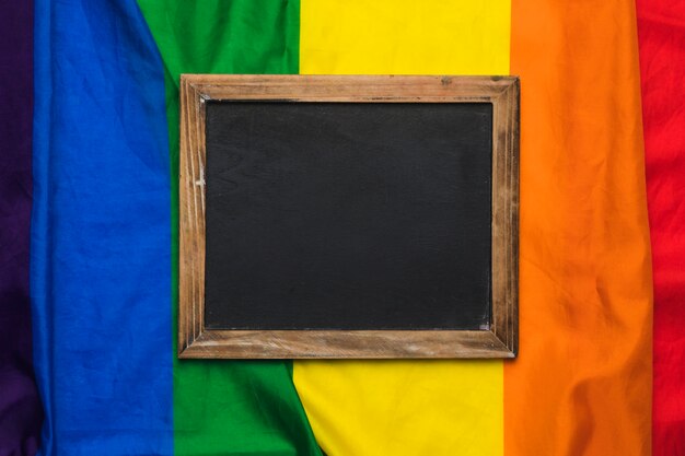 Lavagna vuota sulla bandiera arcobaleno