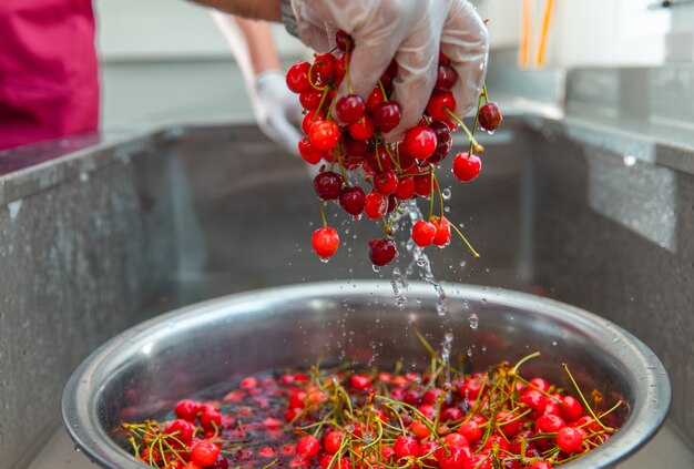 Lavare le ciliegie rosse nell'acqua