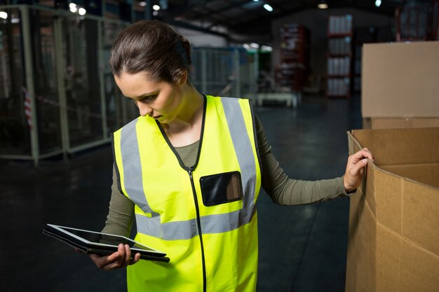 Lavoratore di sesso femminile che utilizza tablet pc in magazzino