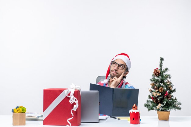 Lavoratore maschio di vista frontale che si siede nel suo posto di lavoro che legge il quaderno