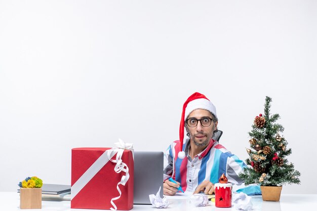 Lavoratore maschio di vista frontale che si siede nel suo posto di lavoro che scrive note