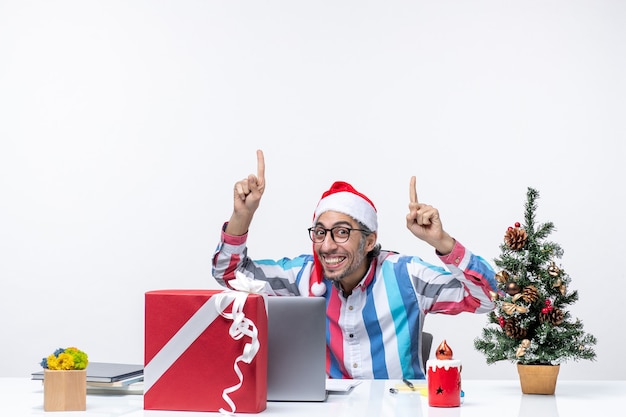 Lavoratore maschio di vista frontale che si siede nel suo posto di lavoro che sorride emozione di lavoro di natale di affari