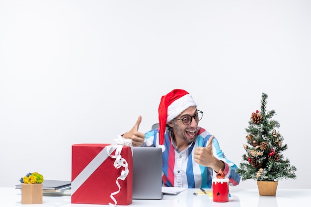 Lavoratore maschio vista frontale seduto al suo posto in posa sentendosi eccitato lavoro di natale d'ufficio