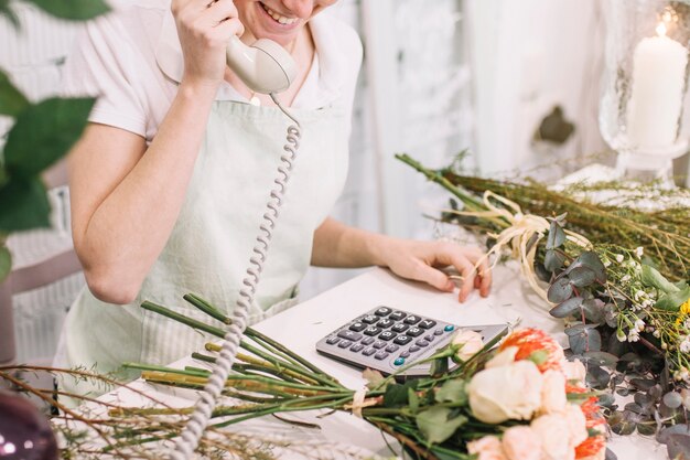 Lavoratore ridendo parlando sul telefono nel negozio