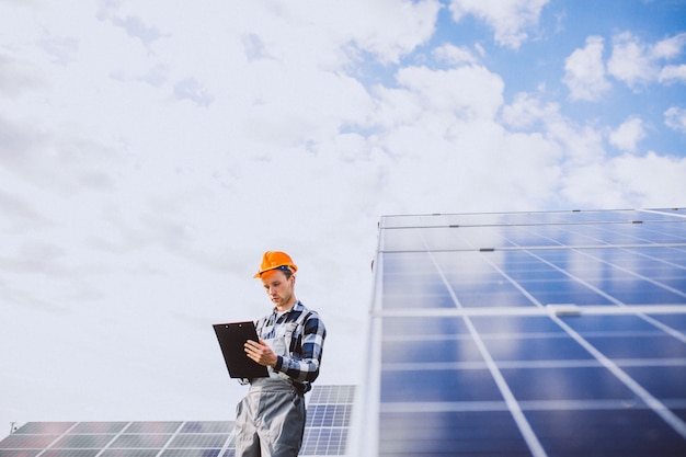 Lavoratore uomo nel firld dai pannelli solari