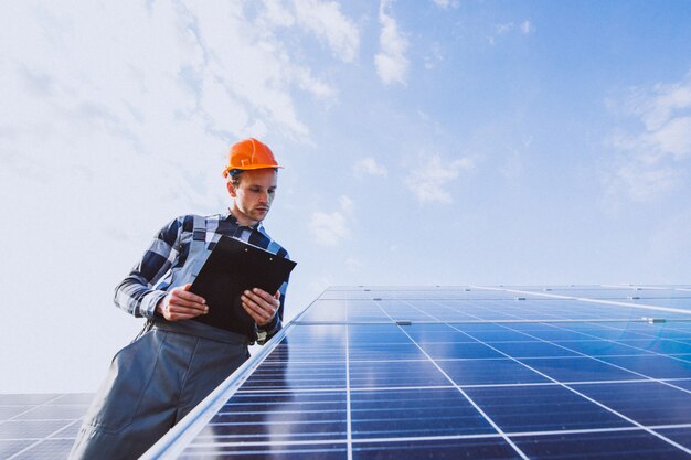 Lavoratore uomo nel firld dai pannelli solari