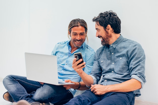 lavoratori felici con il computer portatile e telefono cellulare