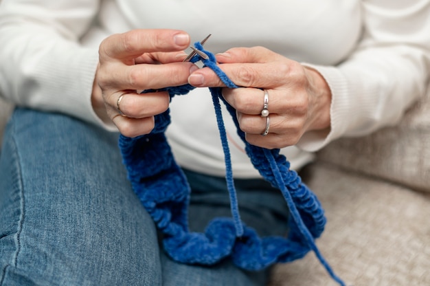 Lavoro a maglia senior della donna dell'angolo alto a casa