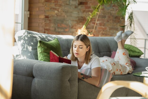 Lavoro di carta. Donna caucasica, libera professionista durante il lavoro in ufficio a casa durante la quarantena. Giovane imprenditrice a casa, auto isolata. Utilizzo di gadget. Lavoro a distanza, prevenzione della diffusione del coronavirus.