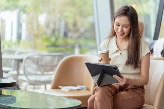 Lavoro di felicità di carriera di nomade digitale freelance femminile asiatico allegro sorridente che lavora online con smartphone tablet dispositivo intelligente progetto di occupazione all'estero lavoro ovunque nuovo stile di vita senza cornice