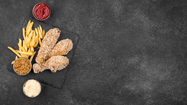 Lay piatto di pollo fritto con patatine fritte e salse