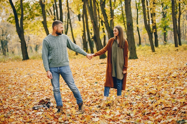 Le belle coppie passano il tempo in un parco di autunno