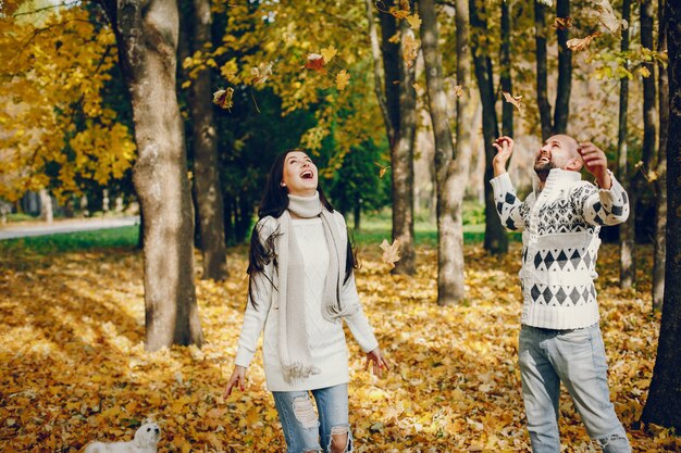 Le belle coppie passano il tempo in un parco di autunno