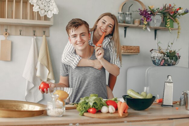 Le belle coppie preparano l'alimento in una cucina