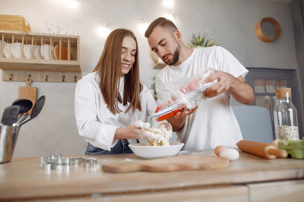 Le belle coppie preparano l'alimento in una cucina