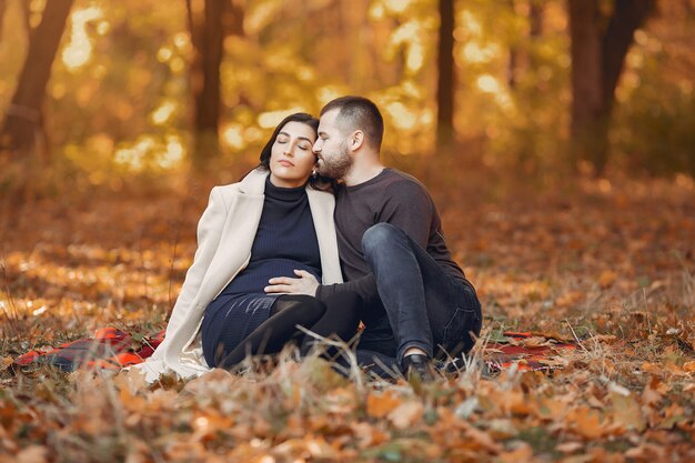 Le belle coppie trascorrono il tempo in un parco di autunno