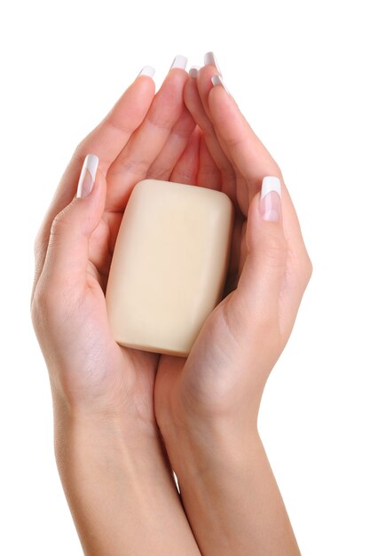 Le belle mani femminili tengono il sapone bianco