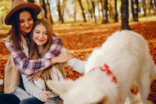 Le belle ragazze si divertono in un parco in autunno