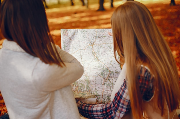 Le belle ragazze si divertono in un parco in autunno